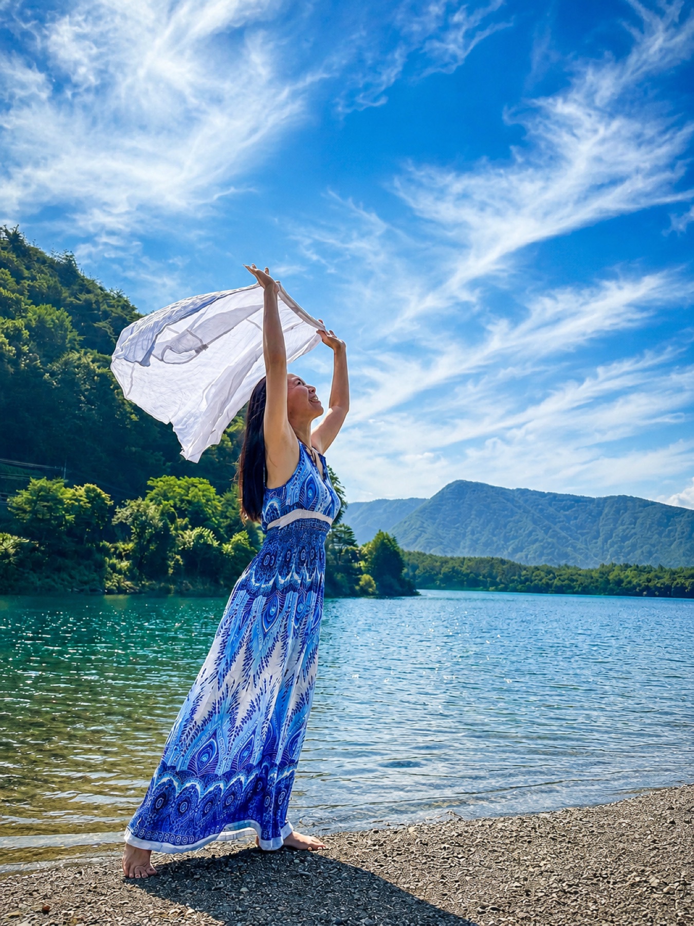 湖の前で白い布を広げるやすよ